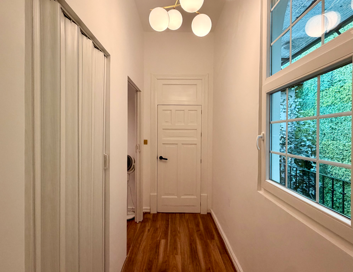 Clean and bright wax studio interior featuring modern white paneled doors, luxury lighting, and a professional treatment room setup.